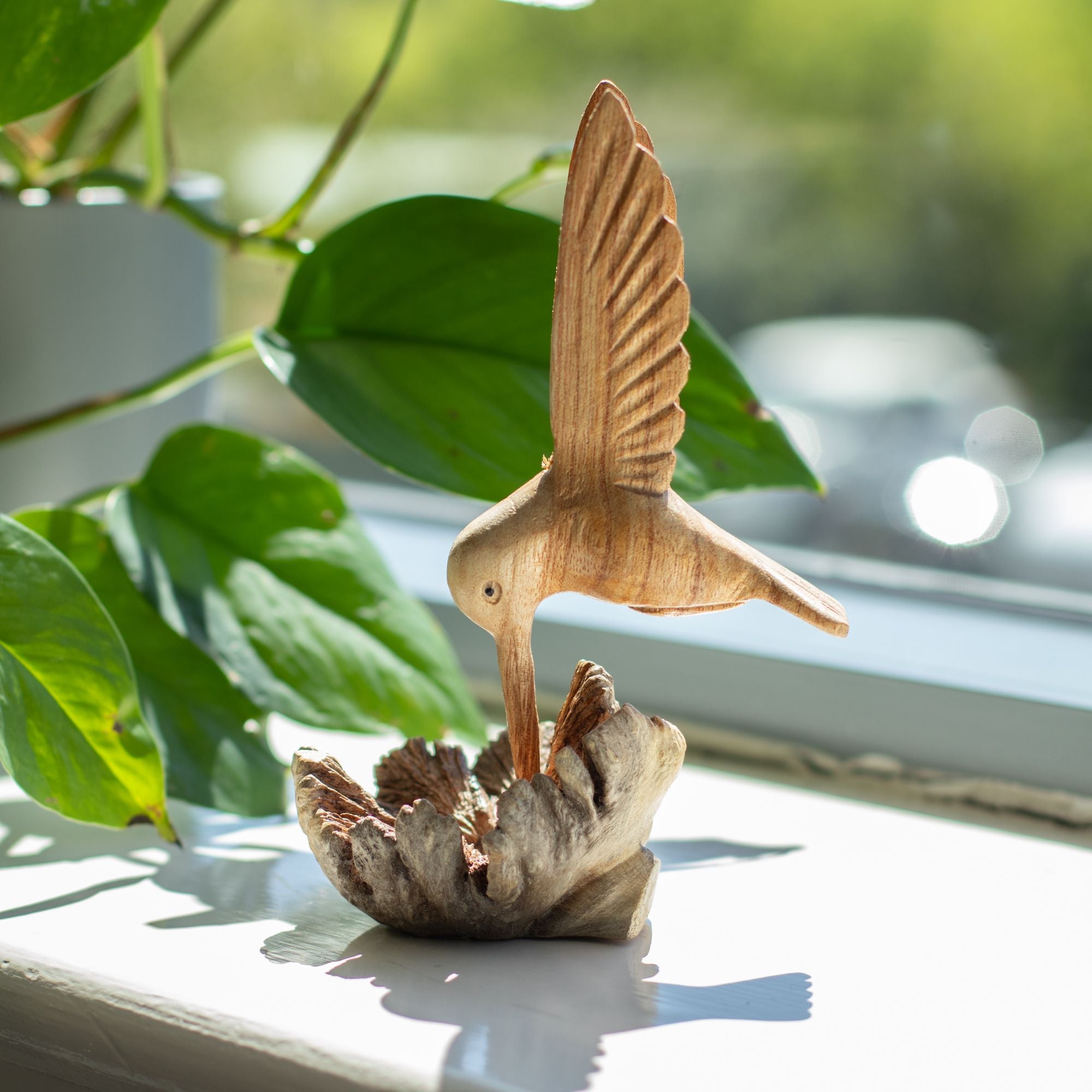 Ručne vyrobená socha kolibríka pijúceho nektár z drevnej nádory