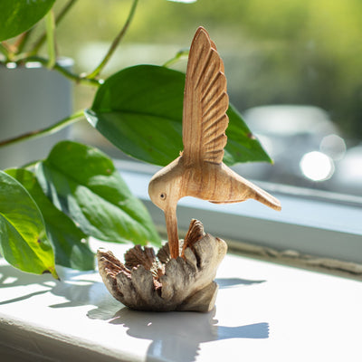 Ručne vyrobená socha kolibríka pijúceho nektár z drevnej nádory