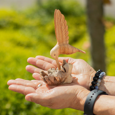 Ručne vyrobená socha kolibríka pijúceho nektár z drevnej nádory